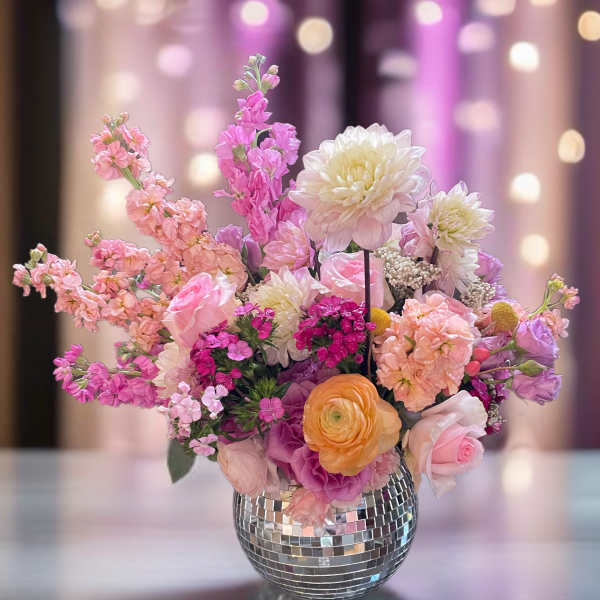 Pink and white mixed flower arrangement in a mirrored vase