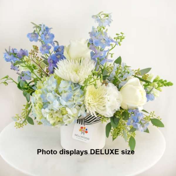 Blue and white floral arrangement in a white vase