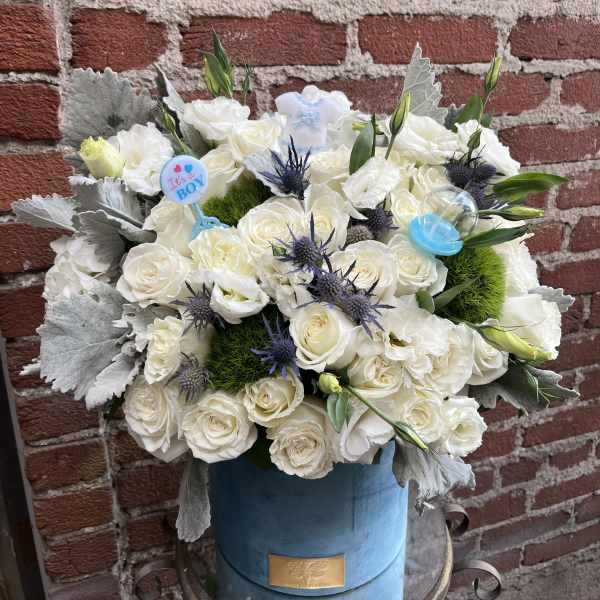 White rose bouquet in a blue hatbox with baby-themed picks