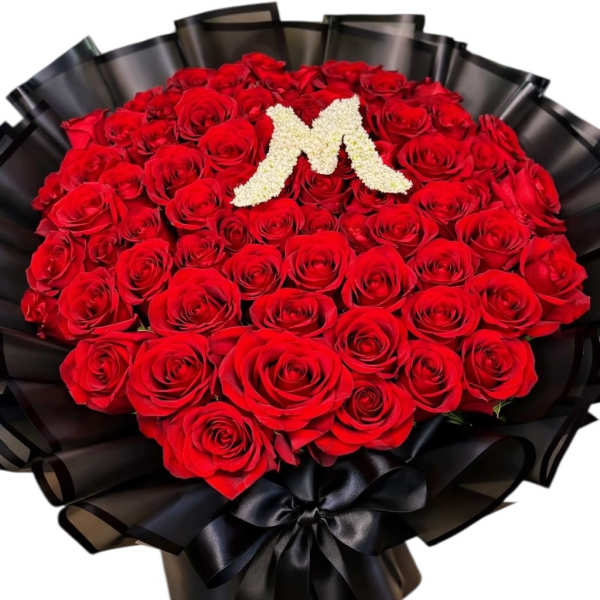 Large bouquet of red roses with a white floral letter M and black wrapping