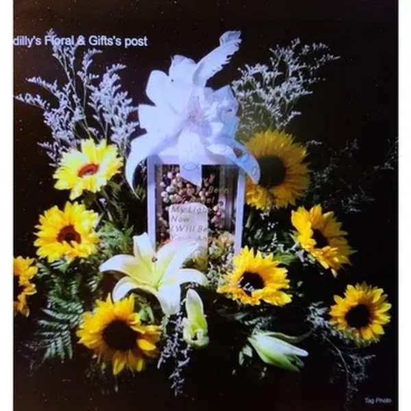 Sunflower and lily funeral spray with a white bow and framed photo