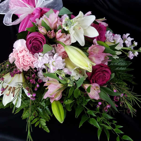 Pink and white mixed bouquet with lilies and roses tied with a ribbon
