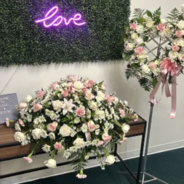 Pink and white floral arrangements with a neon love sign