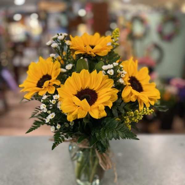 Bouquet of yellow sunflowers in a clear glass vase