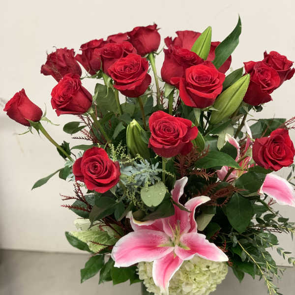 Red roses and pink lilies in a clear glass vase