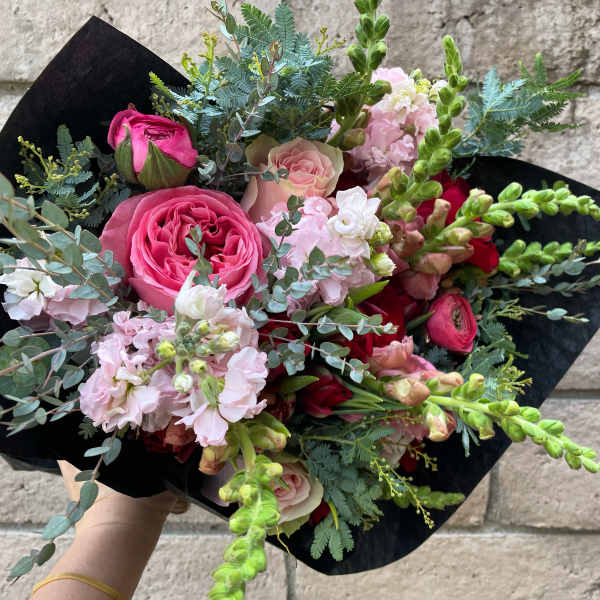 Pink and red mixed bouquet wrapped in black paper