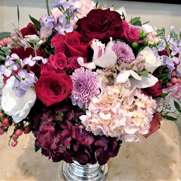 Bouquet of red roses, pink and white flowers in a silver vase