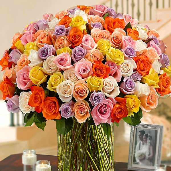 Large bouquet of multicolored roses in a clear glass vase
