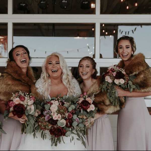Bride and bridesmaids holding burgundy and blush bouquets