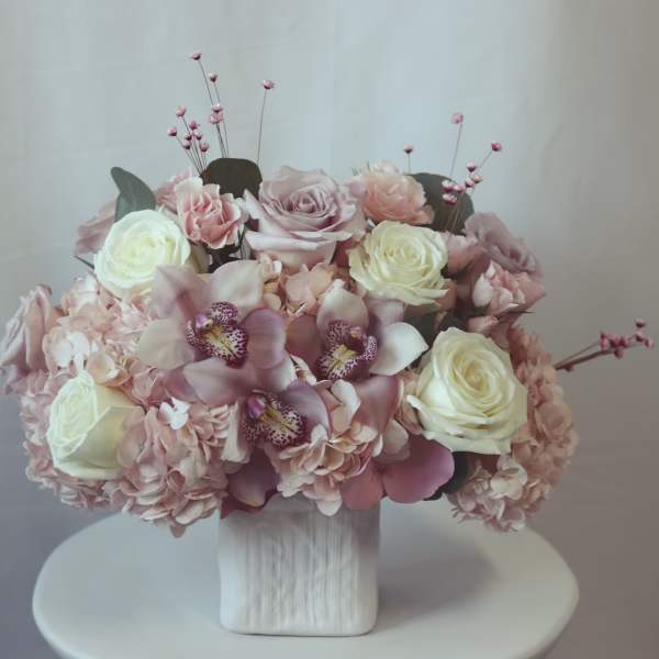 Pink and white floral arrangement in a white vase