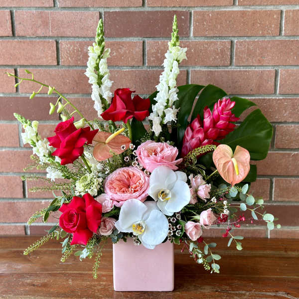 Mixed bouquet in a pink vase with red, pink, white, and peach flowers