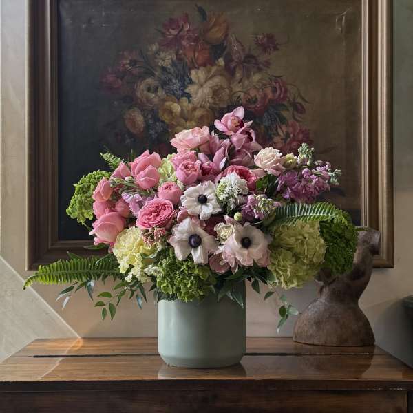 Pink and white mixed flower arrangement in a pale green vase