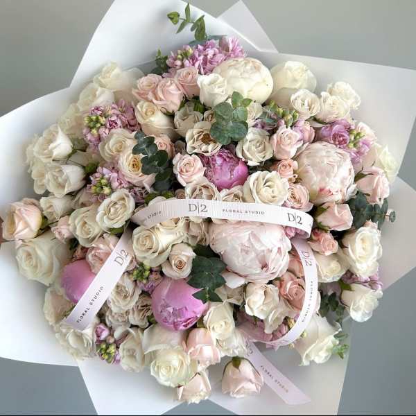 Bouquet of blush and white roses with peonies wrapped in white paper