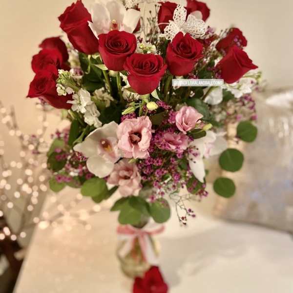 Bouquet of red roses and pink flowers with white butterfly accents