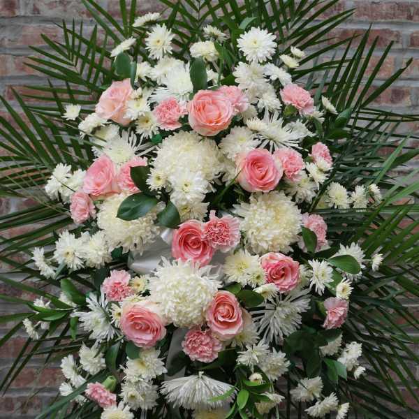 Pink roses and white chrysanthemums arranged in a large standing spray