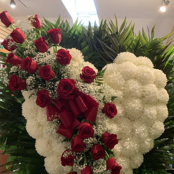 Heart-shaped floral spray with red roses and white flowers