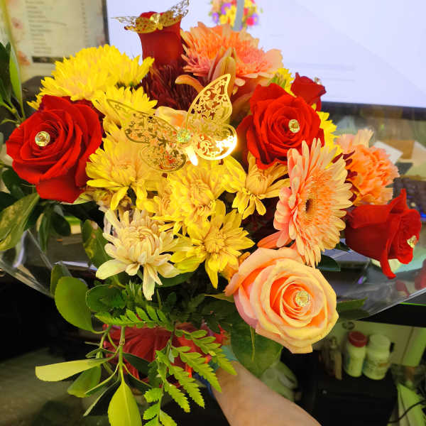 Bouquet of red roses, yellow chrysanthemums, and peach gerbera daisies
