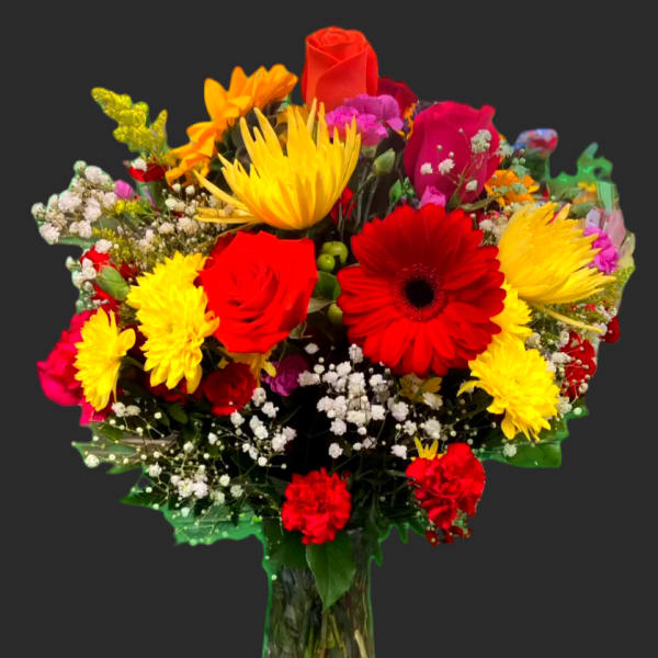 Mixed bouquet of red, yellow, and pink flowers in a glass vase