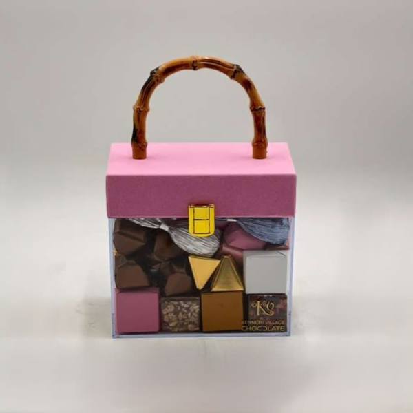 Pink gift box with assorted chocolates and a bamboo handle