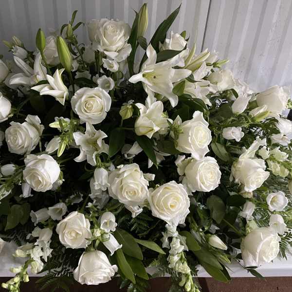 Large white floral arrangement with roses and lilies
