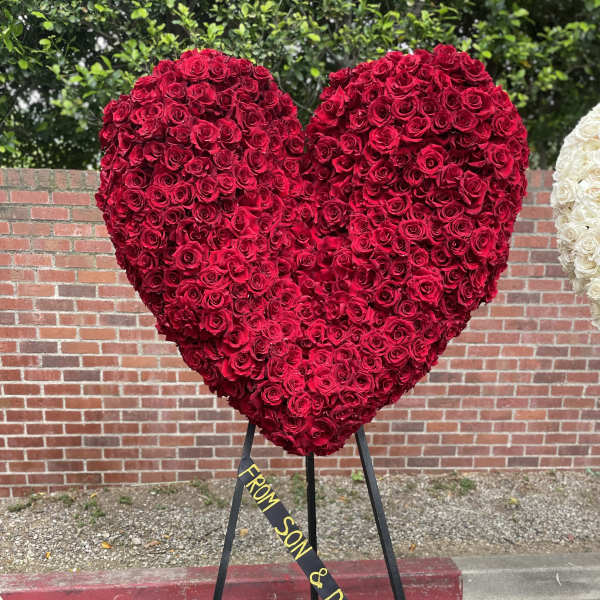 Large heart-shaped red rose arrangement on a stand