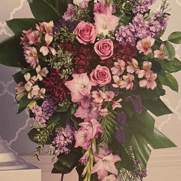 Large pink and purple floral standing spray with roses and lilies
