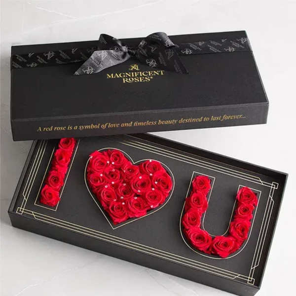 Black gift box with red roses arranged to spell I love you