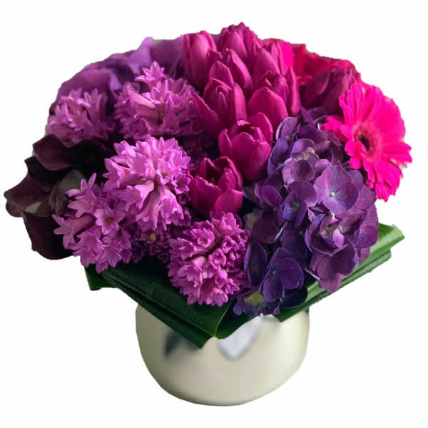 Purple and pink bouquet in a white vase