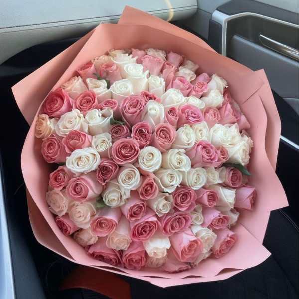 Large bouquet of pink and white roses wrapped in pink paper