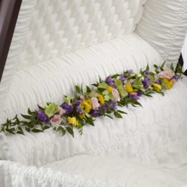 Floral garland with purple, yellow, and pink blooms on a white chair