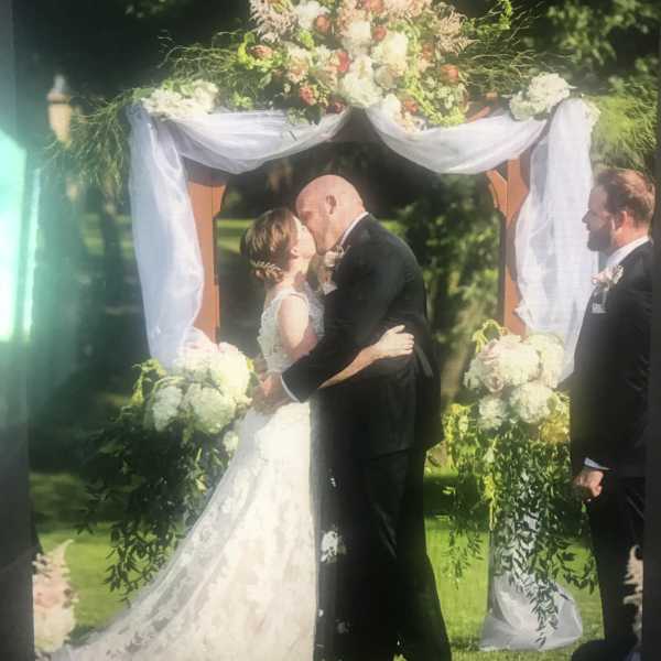 Wedding arch decorated with white and blush flowers and draped fabric