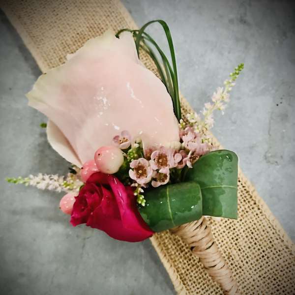 Pink calla lily and rose boutonniere with small pink flowers