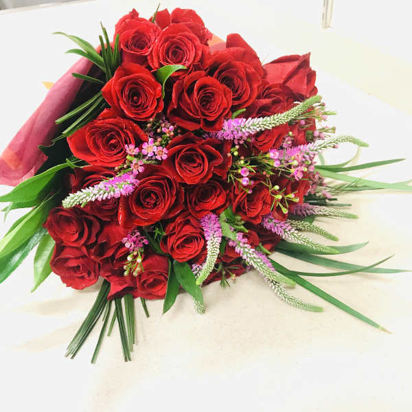 Bouquet of red roses with pink filler flowers and greenery