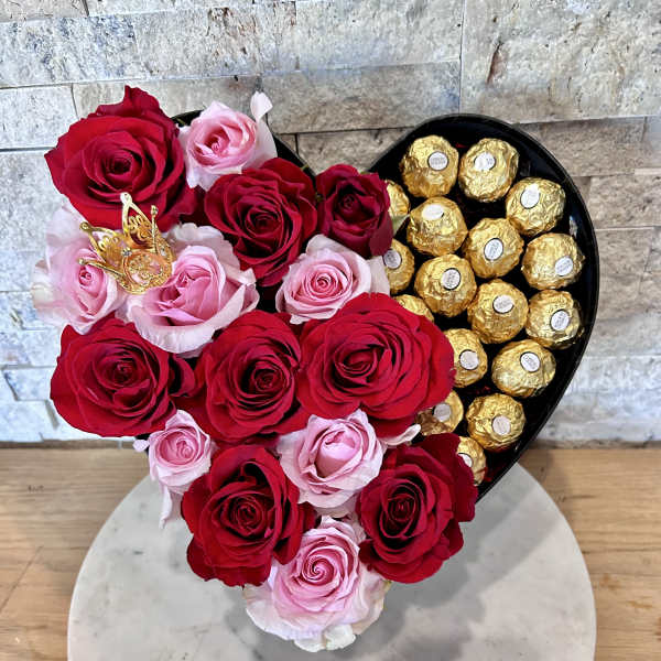 Heart-shaped box with red and pink roses and gold-wrapped chocolates