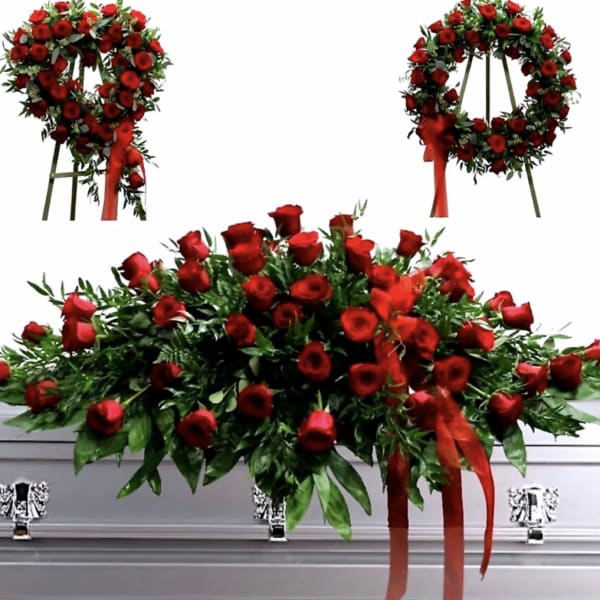 Red rose casket spray with ribbon accents