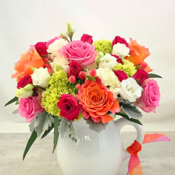 Colorful rose bouquet in a white pitcher vase