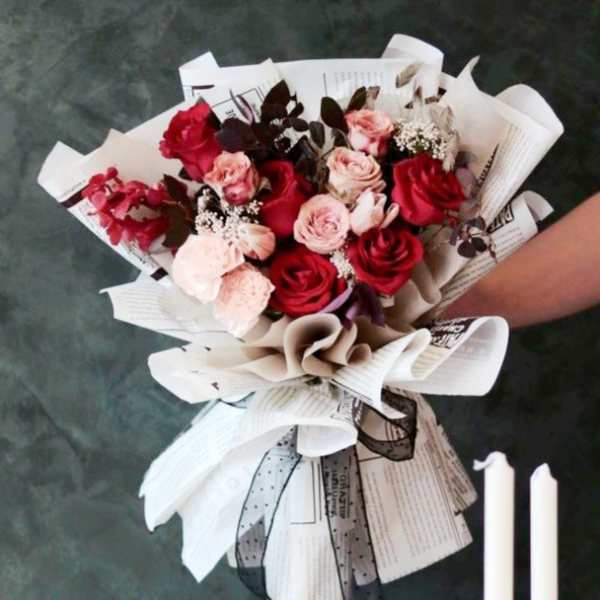 Bouquet of red and blush roses wrapped in paper