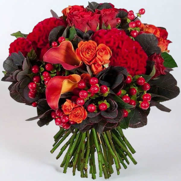Bouquet of red roses, orange calla lilies, and red berries