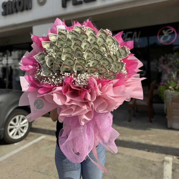 Bouquet of folded dollar bills wrapped in pink paper and mesh