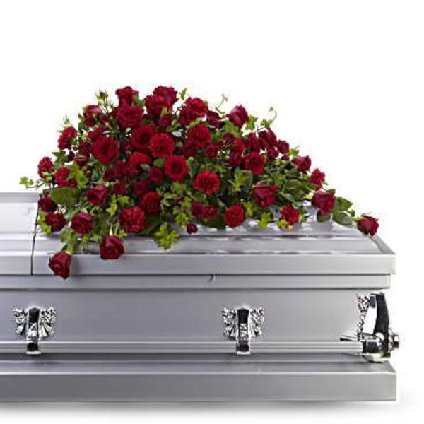Red rose spray on a silver casket