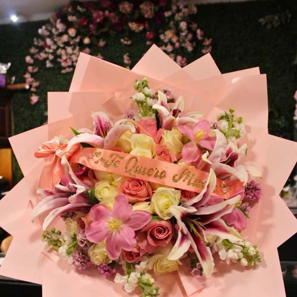 Pink bouquet with roses and lilies wrapped in pastel paper