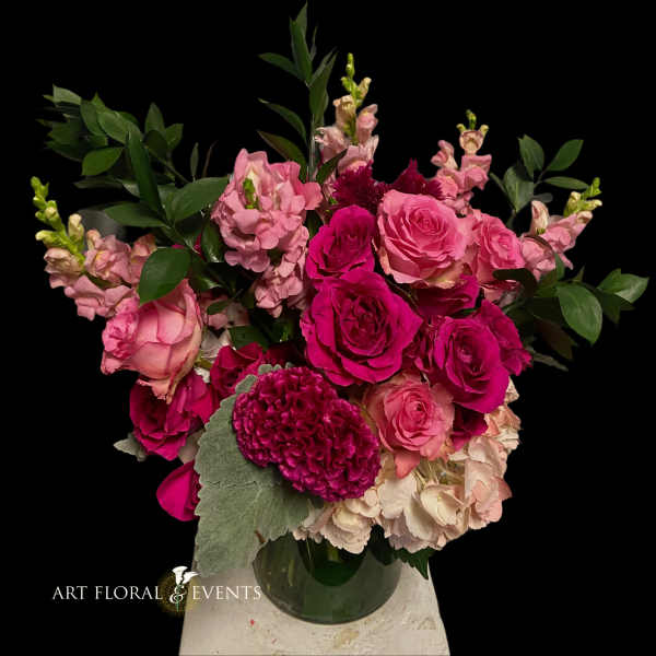 Pink rose bouquet with snapdragons and greenery in a glass vase