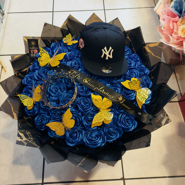 Blue rose bouquet with a black baseball cap and gold butterfly decorations