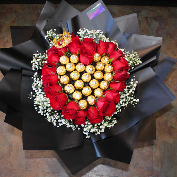 Heart-shaped bouquet of red roses with chocolates in black wrap