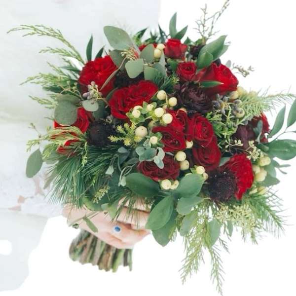 Bouquet of red roses with mixed greenery and white berries