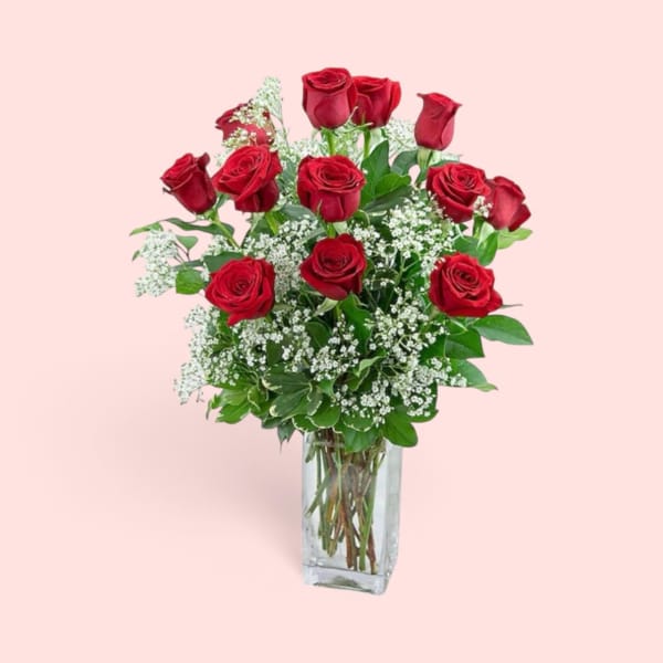 Bouquet of red roses and baby's breath in a clear glass vase