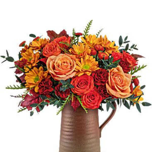 Bouquet of orange and red flowers in a brown pitcher vase
