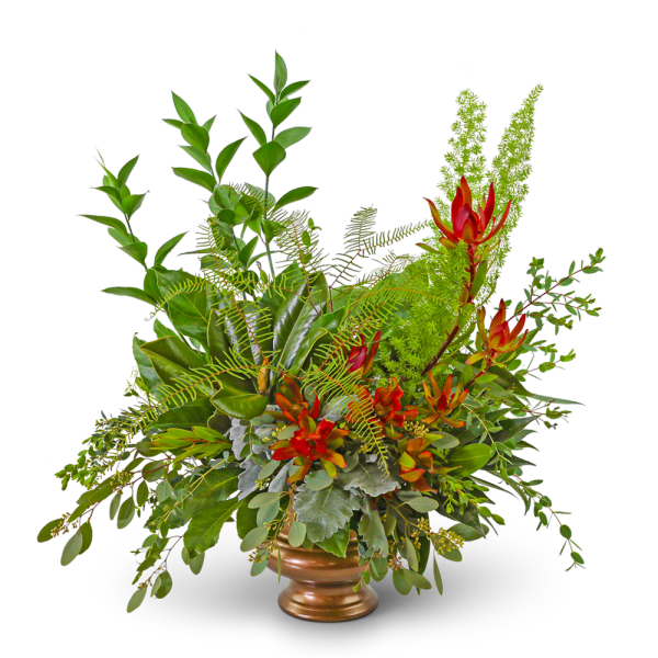 Tropical floral arrangement with red-orange blooms in a bronze vase