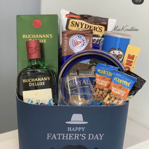 Father's Day gift basket with whiskey, snacks, and a blue box