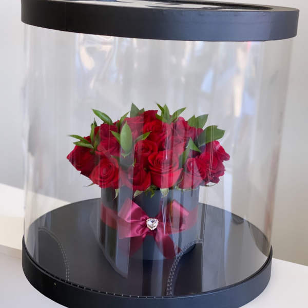 Red roses in a black hatbox with a clear dome cover